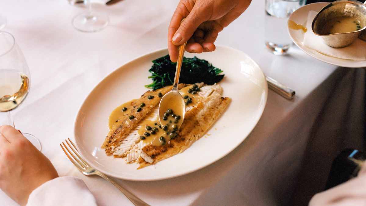 A waiter serving a dish